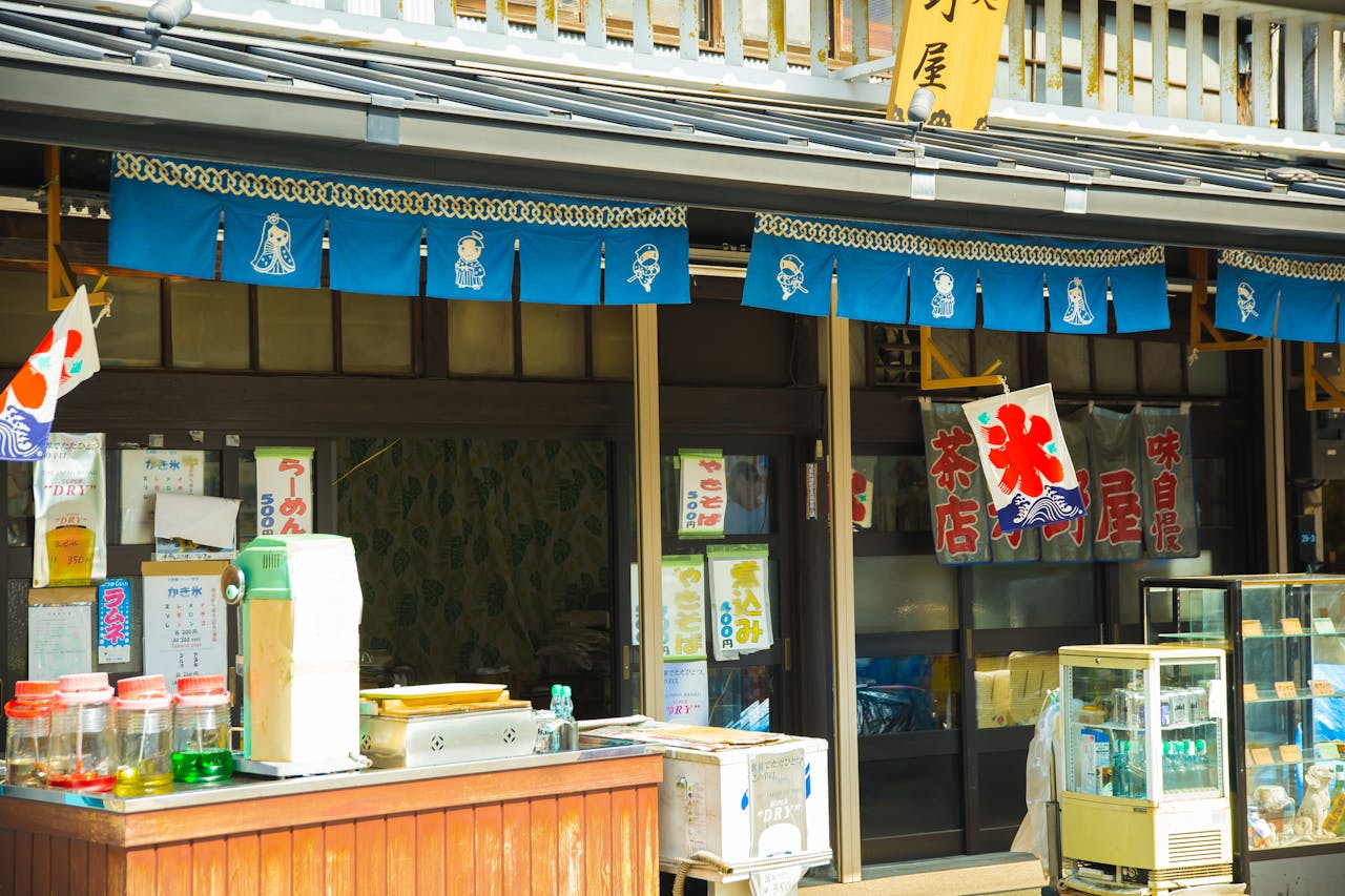 Charming view of a traditional Japanese street shop in Tokyo, adorned with colorful banners and signage.